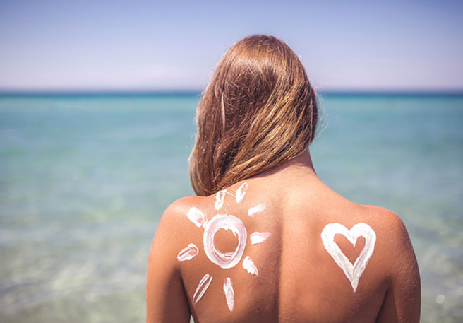 Frau mit Sonnencreme auf dem Rücken