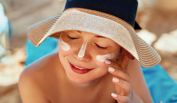 Frau cremt ihr Gesicht ein Sonnenbrand Dauer mit der richtigen Pflege verkürzen